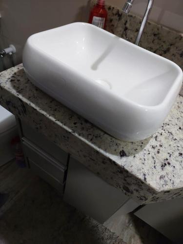 a white sink sitting on top of a counter at Casa de temporada in Rio Verde