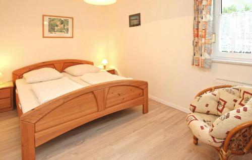 sypialnia z drewnianym łóżkiem i krzesłem w obiekcie Awesome Apartment In Rechlin With Kitchen w mieście Rechlin