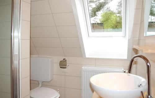 a bathroom with a sink and a toilet and a window at Nice Apartment In Dierhagen ostseebad With Wifi in Neuhaus