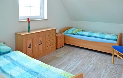 a bedroom with two beds and a desk and a window at 2 Bedroom Lovely Apartment In Feldberger Seenlandsch in Conow