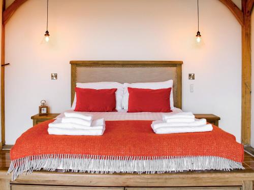 a bedroom with a red bed with red pillows at Oak View in Highgate