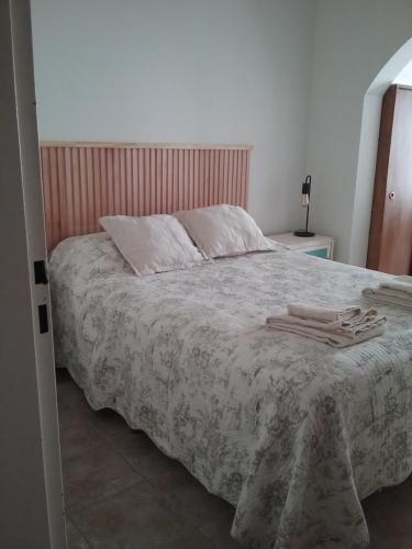 a bedroom with a large bed with towels on it at Patagonia Tilly in Rada Tilly