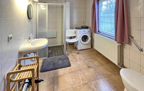 a bathroom with a sink and a washing machine at 3 Bedroom Pet Friendly Apartment In Eldetal Ot Wredenhagen in Wredenhagen