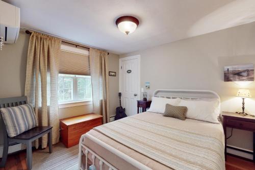 Un dormitorio con una cama y una silla y una ventana. en Periwinkle House, en Harwich