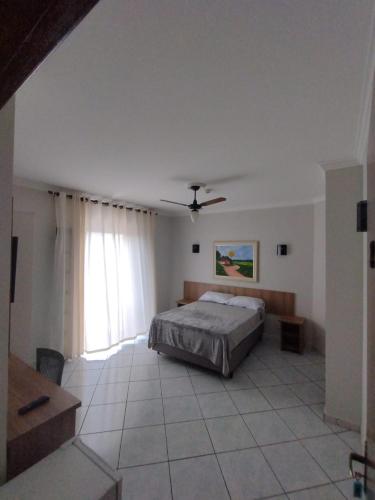um quarto com uma cama e uma ventoinha de tecto em Hotel Nazaré em Nazaré Paulista