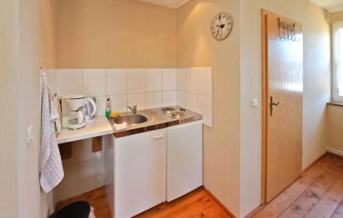 a small kitchen with a sink and a clock on the wall at Cozy Apartment In Meiersberg With Kitchen in Meiersberg