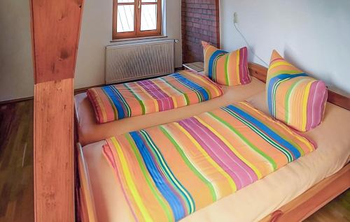 a large bed with colorful sheets and pillows at Beautiful Home In Klpin With Kitchen in Kölpin