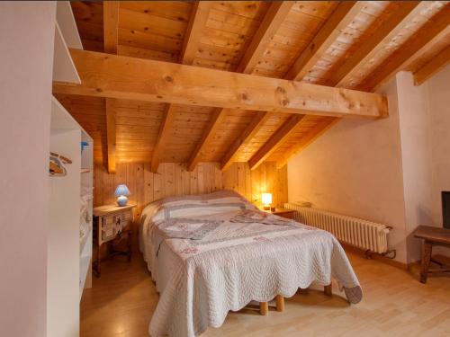 een slaapkamer met een bed in een kamer met houten plafonds bij Chalet Samoëns, 5 pièces, 10 personnes - FR-1-642-3 in Samoëns