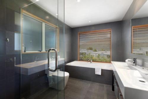 ein Badezimmer mit zwei Waschbecken, einem WC und einer Badewanne in der Unterkunft Shambala in Queenstown