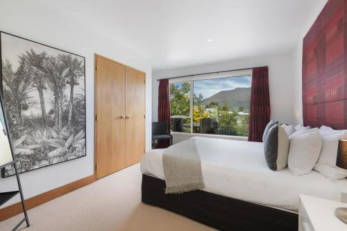 ein Schlafzimmer mit einem großen Bett und einem großen Fenster in der Unterkunft Shambala in Queenstown