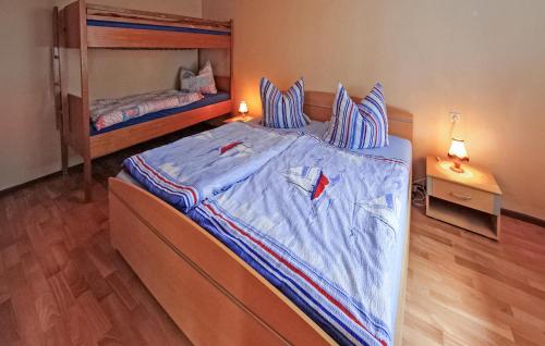 a bedroom with a large bed with blue sheets at Cozy Home In Eggesin With Kitchen in Eggesin