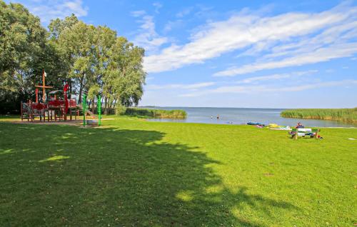 a park with a playground and people on the water at Ferienhaus Kummerow in Kummerow