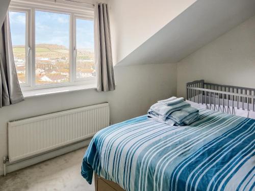 1 dormitorio con 1 cama con manta azul y blanca en Cousens House en Dawlish