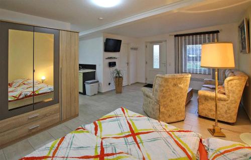 um quarto com uma cama e uma sala de estar com cadeiras em Gorgeous Apartment In Hohen Sprenz With Kitchen em Hohen Sprenz