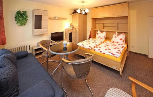 1 dormitorio con cama, mesa y sofá en Gorgeous Home In Lietzow Auf Rgen With Kitchen, en Lietzow
