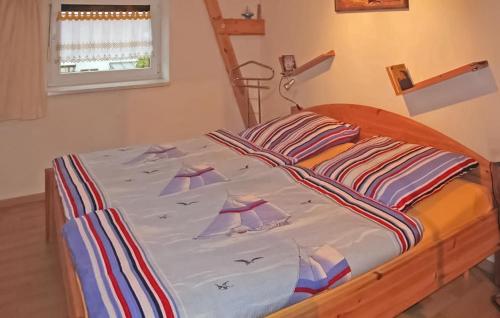 Una cama en un dormitorio con colcha. en Gorgeous Apartment In Mnkebude With Wifi, en Mönkebude