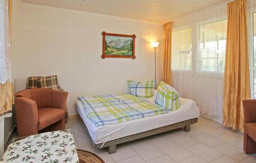 um pequeno quarto com uma cama e uma cadeira em 2 Bedroom Nice Home In Blankensee Ot Wanzka 