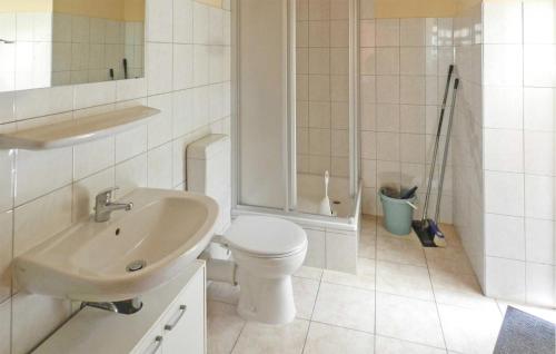 a white bathroom with a toilet and a sink at Nice Home In Boitzenburger Land Ot With Kitchen in Rosenow