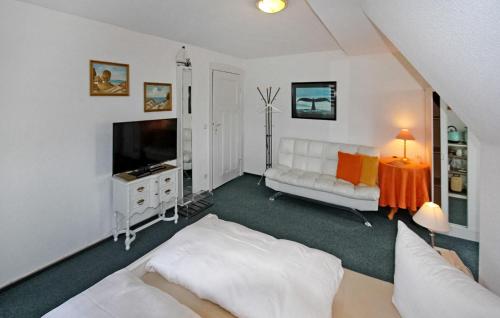 uma sala de estar com um sofá branco e uma televisão em Stunning Apartment In Heringsdorf seebad With Kitchen em Bansin