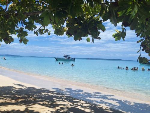 a group of people in the water on a beach at Paraíso frente al Mar. in Carenero