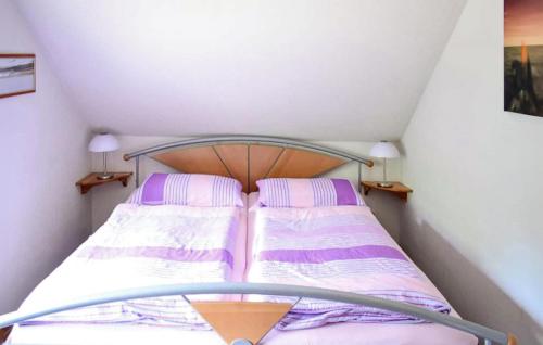 a small bedroom with a bed with purple and white stripes at Gorgeous Apartment In Schwarzenhof With Wifi in Schwarzenhof