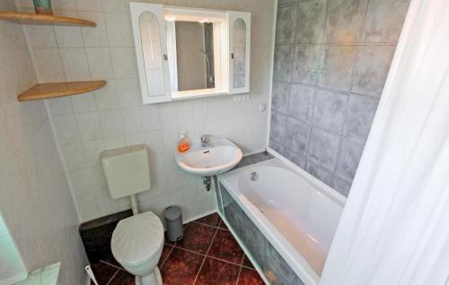 La salle de bains est pourvue d'un lavabo, de toilettes et d'une baignoire. dans l'établissement 2 Bedroom Cozy Apartment In Mirow Ot Qualzow, à Qualzow