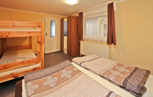 Cette chambre comprend 2 lits superposés et une fenêtre. dans l'établissement Cozy Home In Lubmin seebad With Kitchen, à Lubmin