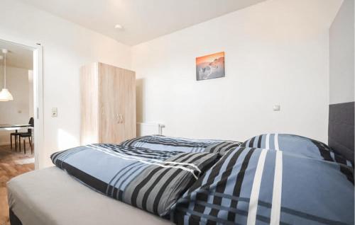 a bed with striped sheets in a white bedroom at Awesome Apartment In Klink With Wifi in Klink