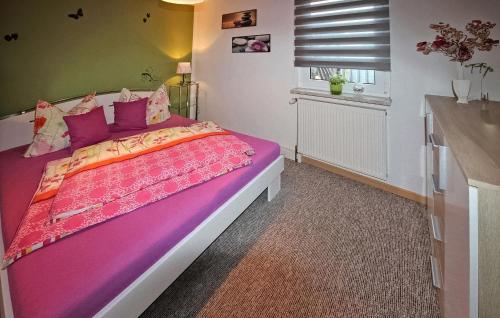 een slaapkamer met een paars bed en een raam bij Amazing Home In Fuhlendorf With Kitchen in Fuhlendorf