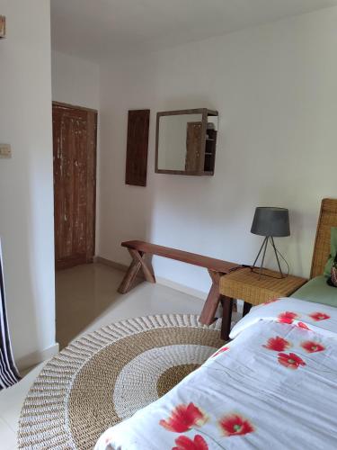 a room with a bed and a table and a mirror at Little Elephant Cottage in Gili Trawangan