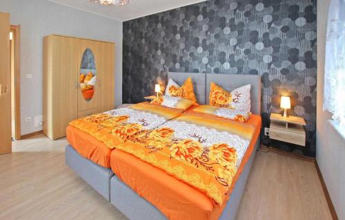 una camera da letto con un grande letto con una coperta arancione di Cozy Apartment In Wesenberg With Kitchen a Wesenberg