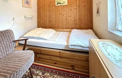 een bed in een kamer met een houten muur bij Amazing Home In Krakow Am See With Kitchen in Krakow am See