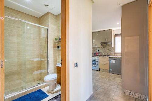 La salle de bains est pourvue de toilettes et d'une douche en verre. dans l'établissement Luxury Living Flat in Prestigia Marrakech, à Marrakech