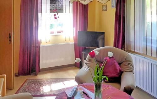 ヴァーレンにあるFerienhaus Waren Müritzのリビングルーム(椅子、花のテーブル付)