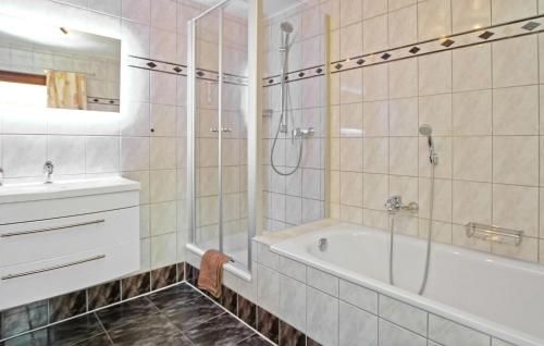 a bathroom with a shower and a tub and a sink at 3 Bedroom Beautiful Apartment In Zislow in Zislow