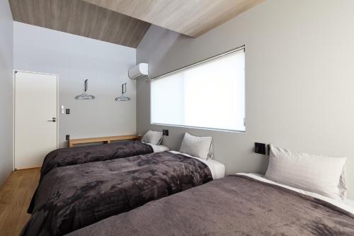 Una cama o camas en una habitación de ロウリュウサウナとアイスバスのあるラグジュアリー貸別荘