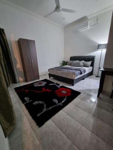 a living room with a bed and a rug at Anzra Home2stay in Kertih