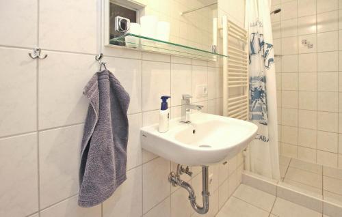 ein weißes Badezimmer mit einem Waschbecken und einem Spiegel in der Unterkunft Amazing Apartment In Waren mritz With Kitchen in Warenshof
