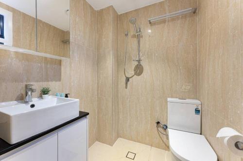 uma casa de banho com um lavatório branco e um WC. em Beautiful 3BR House Close to Central Station em Sydney