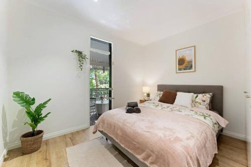 um quarto com uma cama grande e uma planta em Beautiful 3BR House Close to Central Station em Sydney