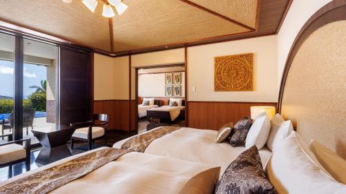 a hotel room with two beds and a balcony at Miyakojima Kurima Resort Seawood Hotel in Miyako Island