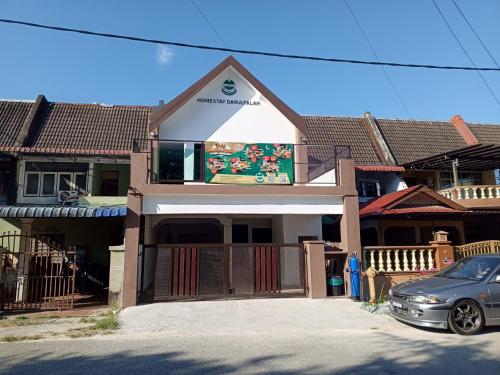 una casa con un coche aparcado delante en HOMESTAY DARULFALAH -Private Pool, en Kuala Terengganu