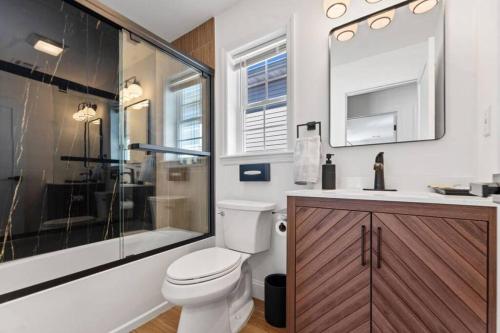 uma casa de banho com um WC, um chuveiro e um lavatório. em Cityscape em Newark