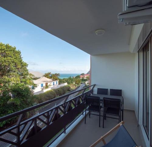 balcón con 2 sillas y vistas al océano en Studio de charme au Gosier en Le Gosier