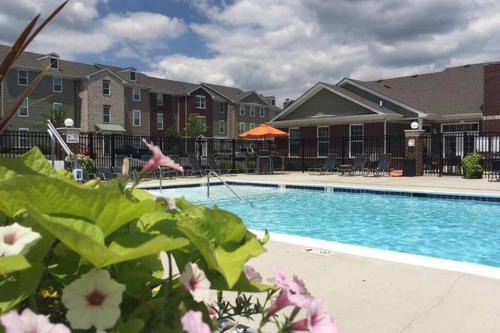 einen Pool in einem Apartmentkomplex mit Blumen in der Unterkunft Luxury 1BR/1BA w/ Top Amenities in Prime Location in Fort Wayne