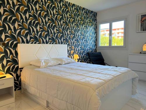 une chambre avec un lit avec un papier peint bleu et or dans l'établissement Appartement 3 pièces refait à neuf avec parking, 4 couchages, proche plage et commerces - Le Lavandou - FR-1-251-584, au Lavandou