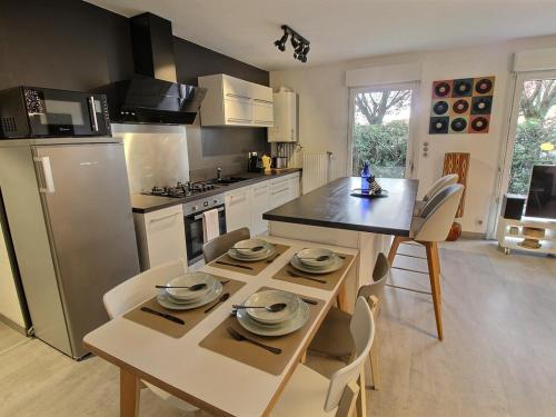 Il comprend une cuisine équipée d'une table et de chaises. dans l'établissement Charmant Appart avec Garage et Terrasse au Coeur de Colmar, près de la Route des Vins d'Alsace - FR-1-722-6, à Colmar