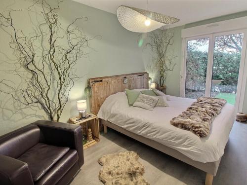 une chambre avec un lit, un canapé et une chaise dans l'établissement Charmant Appart avec Garage et Terrasse au Coeur de Colmar, près de la Route des Vins d'Alsace - FR-1-722-6, à Colmar