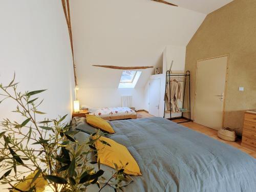 una camera da letto con un letto grande con cuscini gialli di Gîte de charme à la ferme avec jardin clos et activités familiales - FR-1-591-582 a Thenay