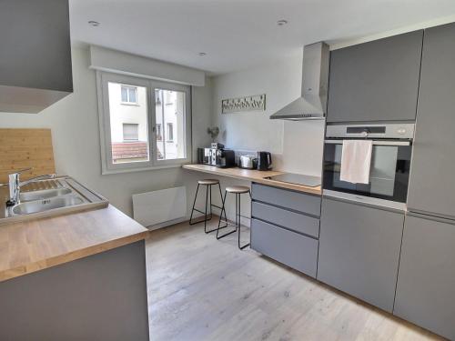 une cuisine avec un évier et une cuisinière four supérieur dans l'établissement Appartement rénové près du centre de Colmar avec balcon, 2 chambres et Wi-Fi inclus - FR-1-722-7, à Colmar